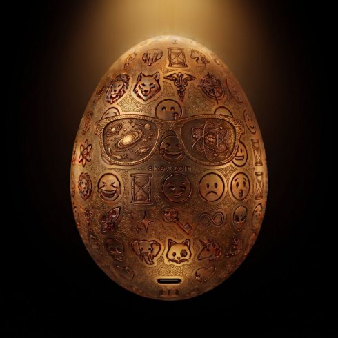 A gold engraved egg lit from above against black.